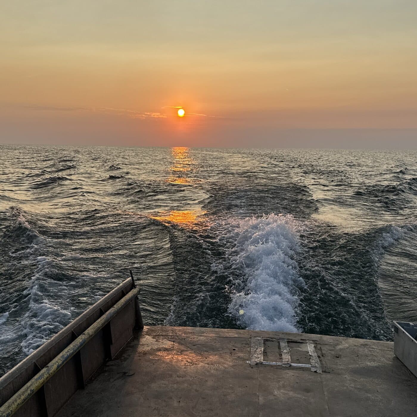 The wake off the stern of the owner's boat at sunset on Lake Erie