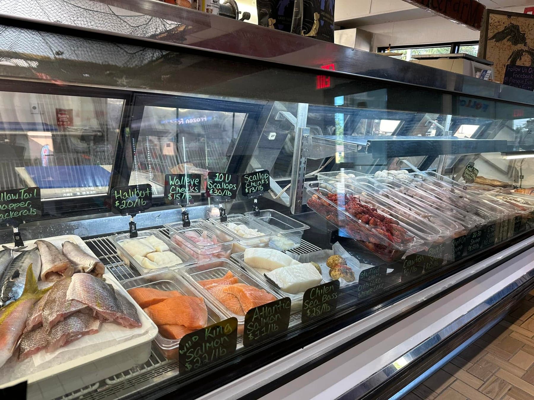 The fresh fish case in the shop, fillets and shellfish on ice with hand-written price signs